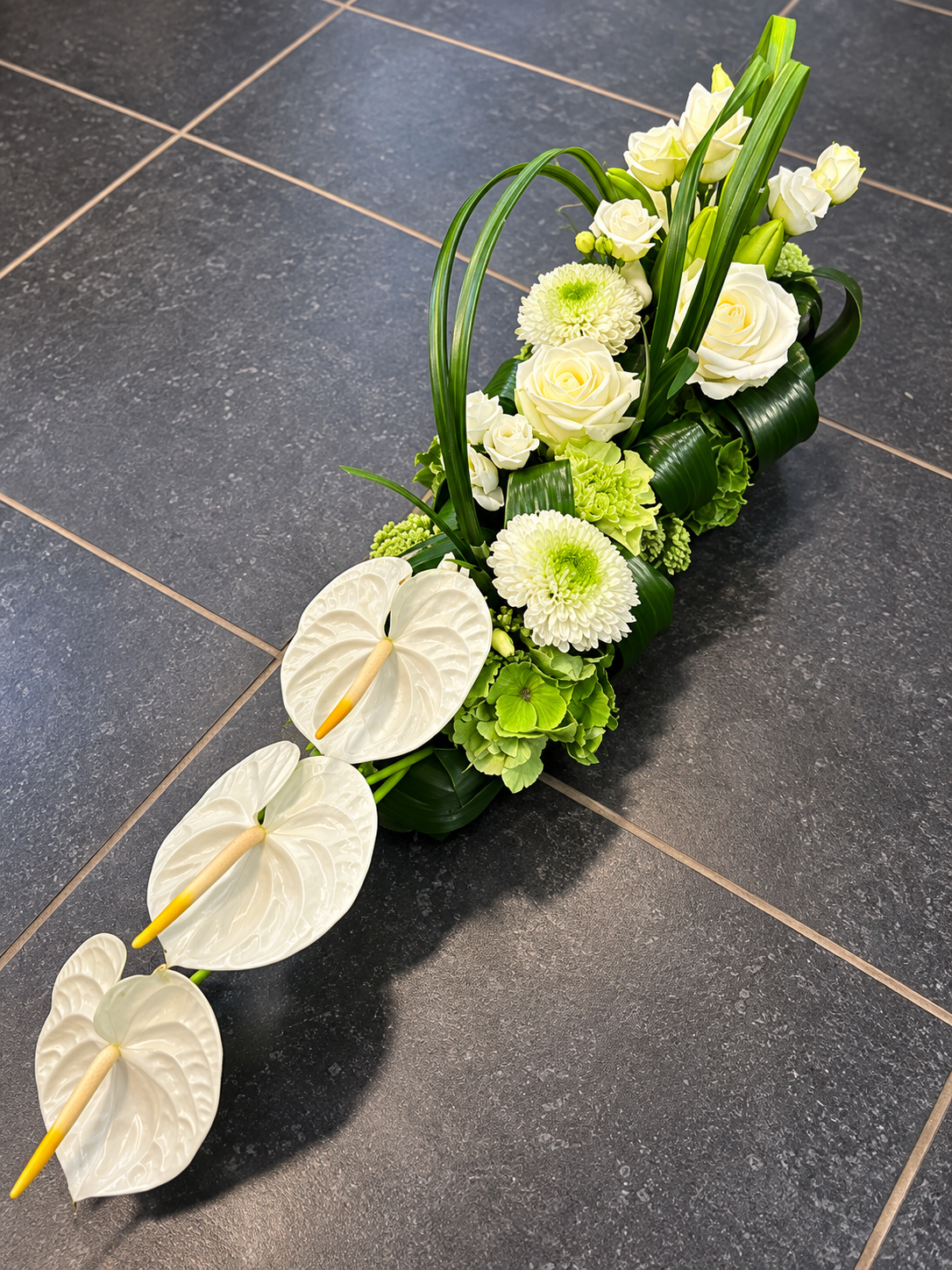 Langwerpig bloemstuk met Anthurium en chrysanten