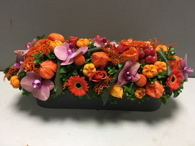 langwerpig bloemstuk in oranje herfstkleuren